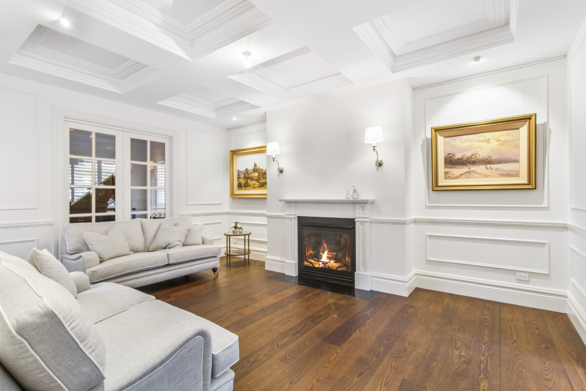 Warm fireplace in traditional white lounge room