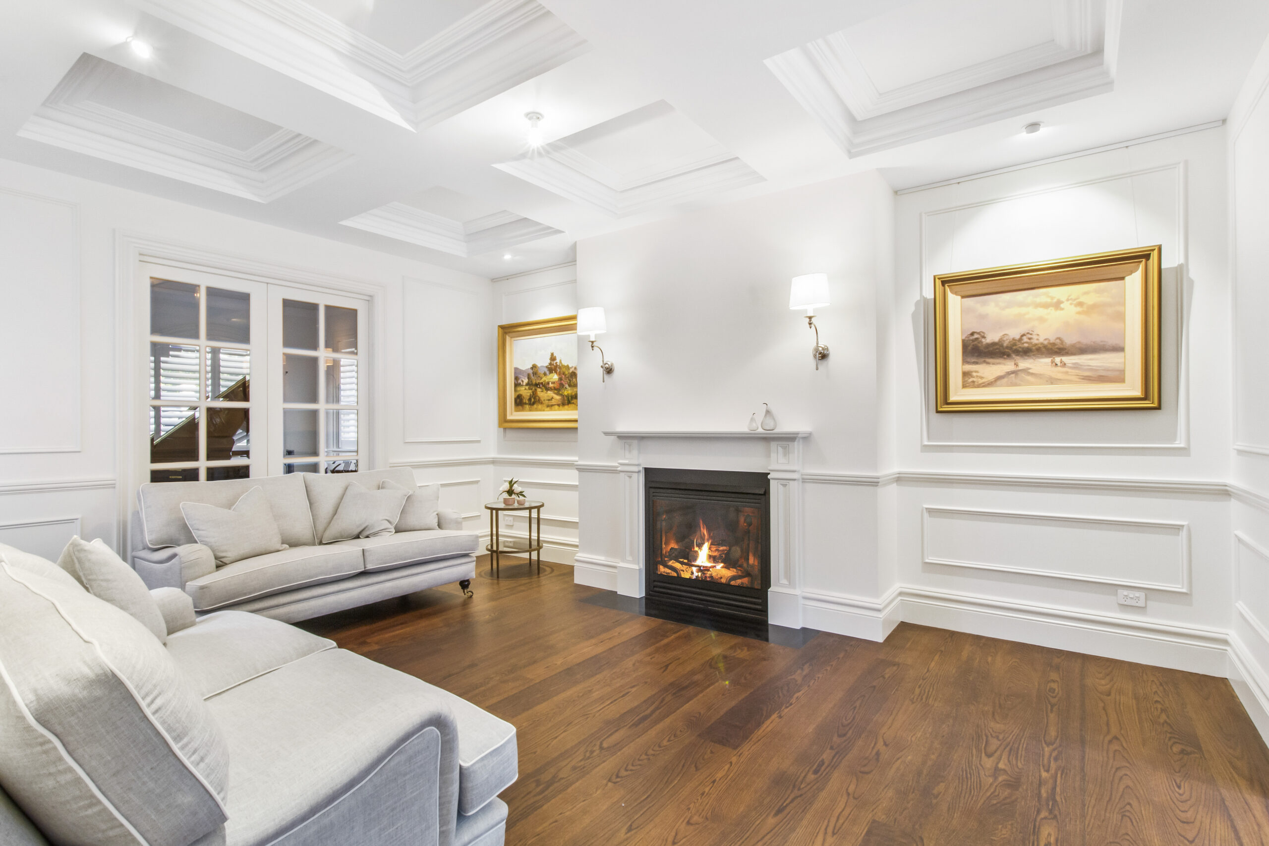 Warm fireplace in traditional white lounge room