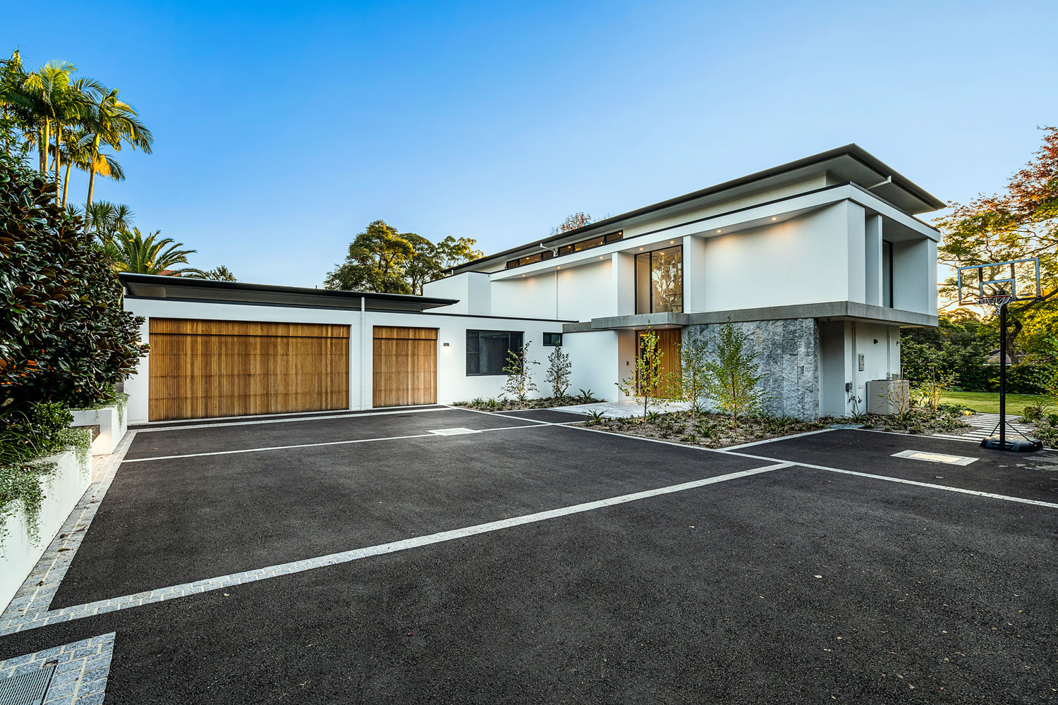 Wide angle view of a modern house, showcasing timber battens across the face of the garage.