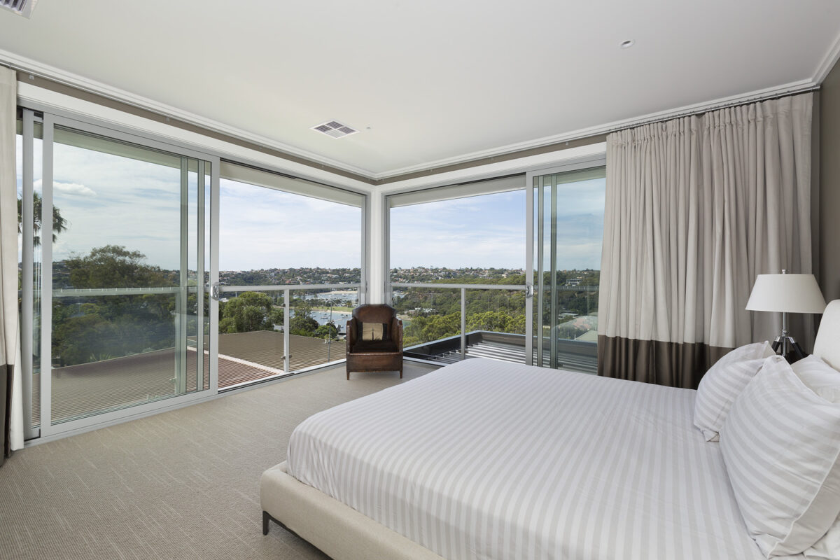 Bedroom with floor to ceiling sliding doors with views to the water