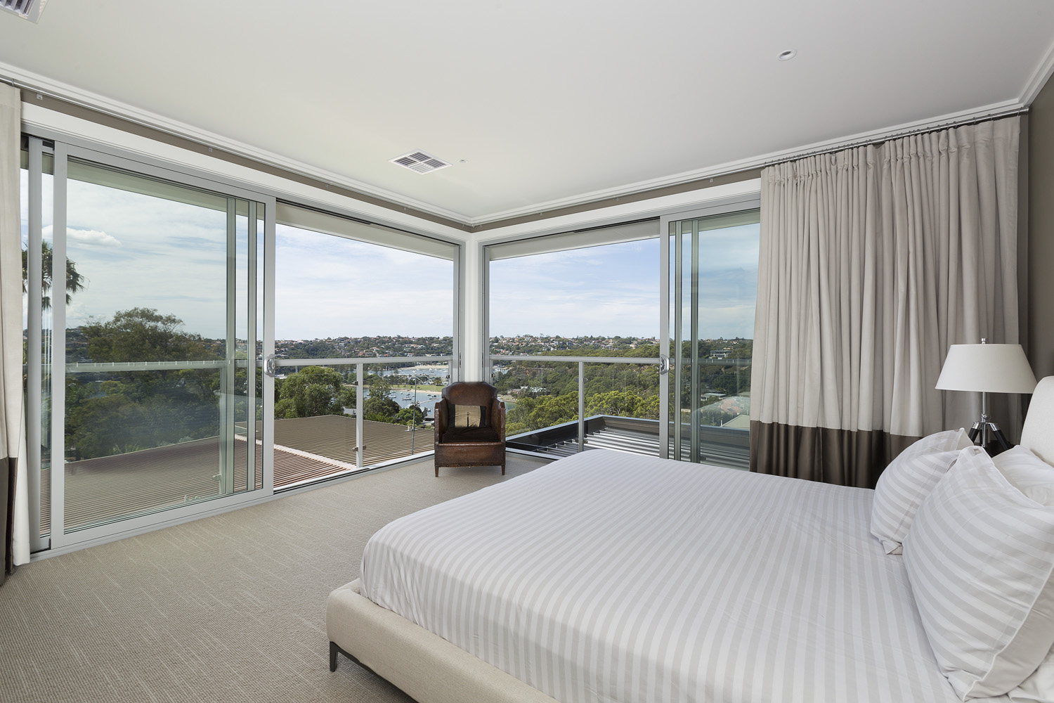 Bedroom with floor to ceiling sliding doors with views to the water