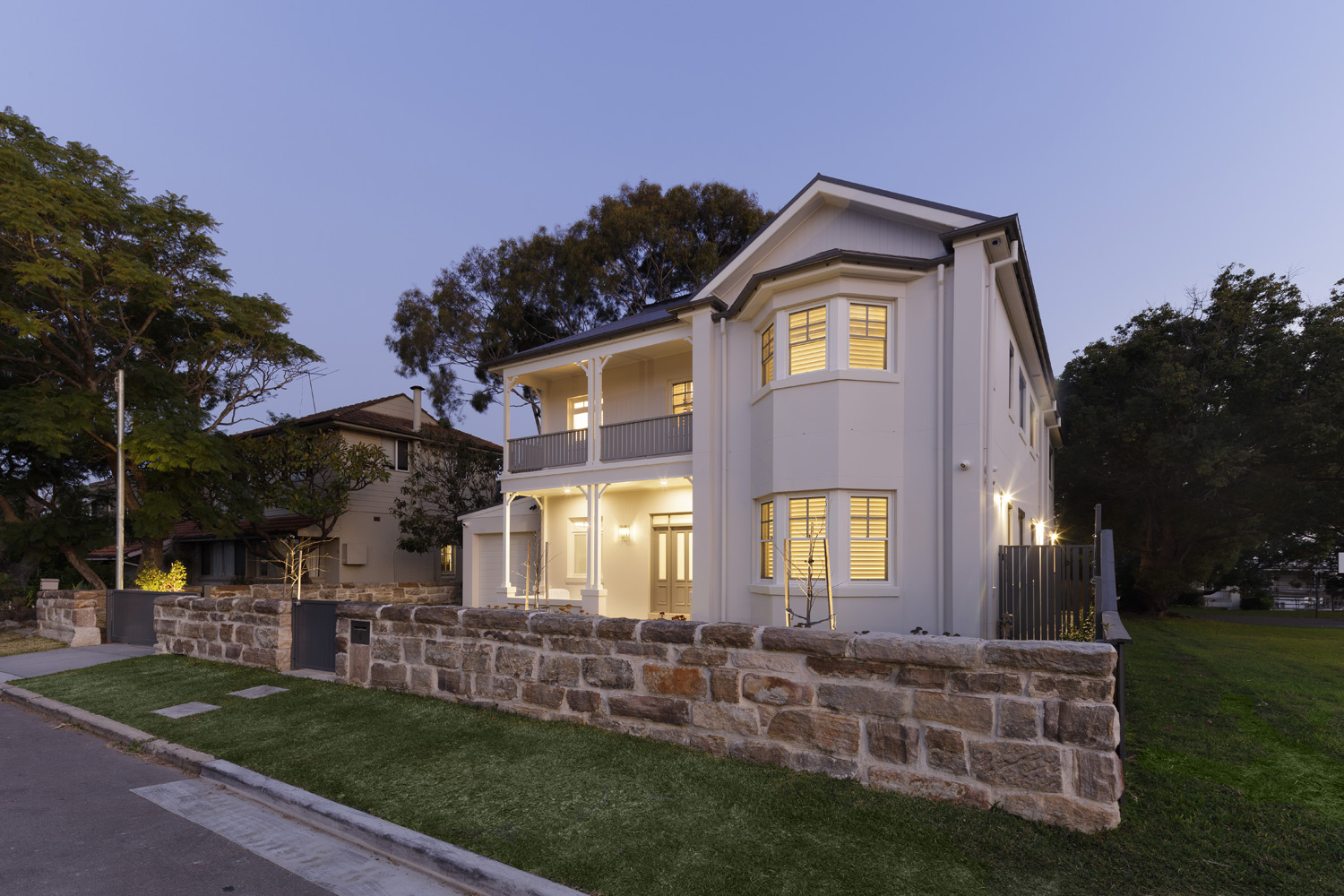 Greenwich Traditional Hamptons: front facade lit up at dusk