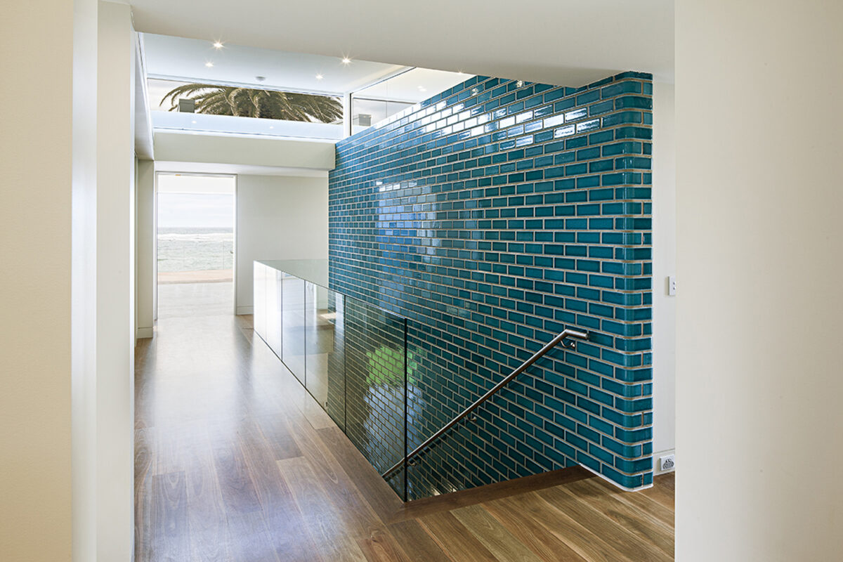 Collaroy Modern Beach: stairwell with feature wall in translucent turquoise tiles