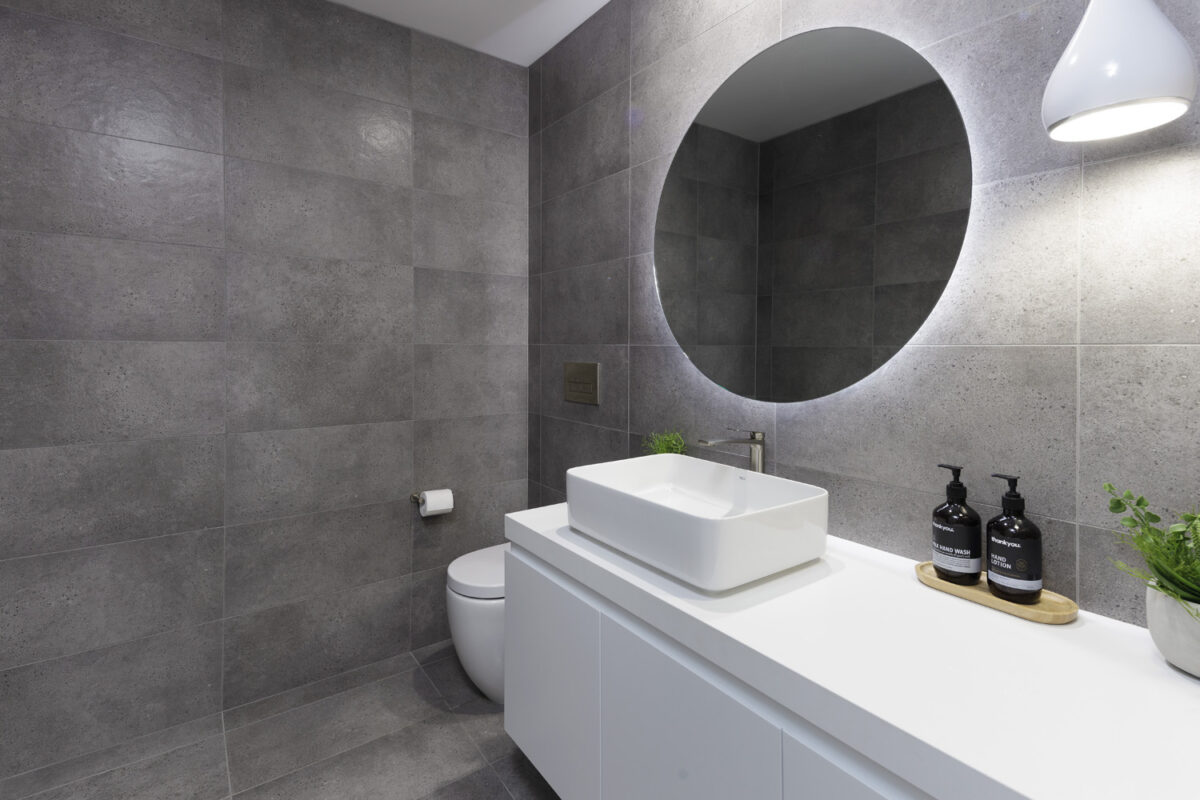 Glenhaven Contemporary Industrial: bathroom with round backlit mirror