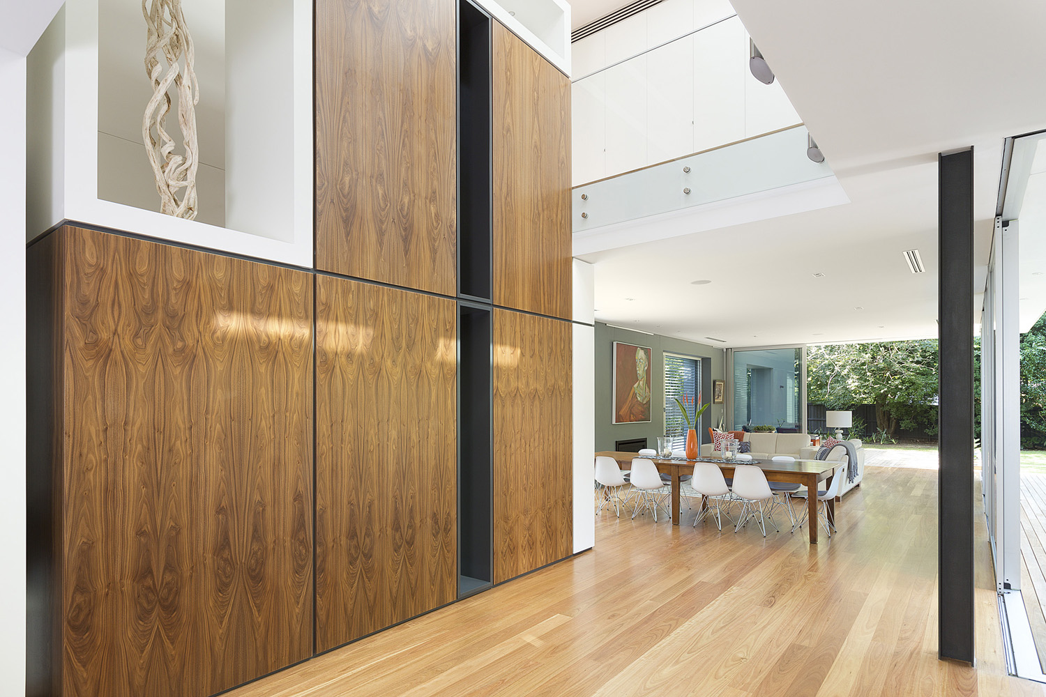 Wahroonga Modern: integrated wooden panel storage upon entry toward dining