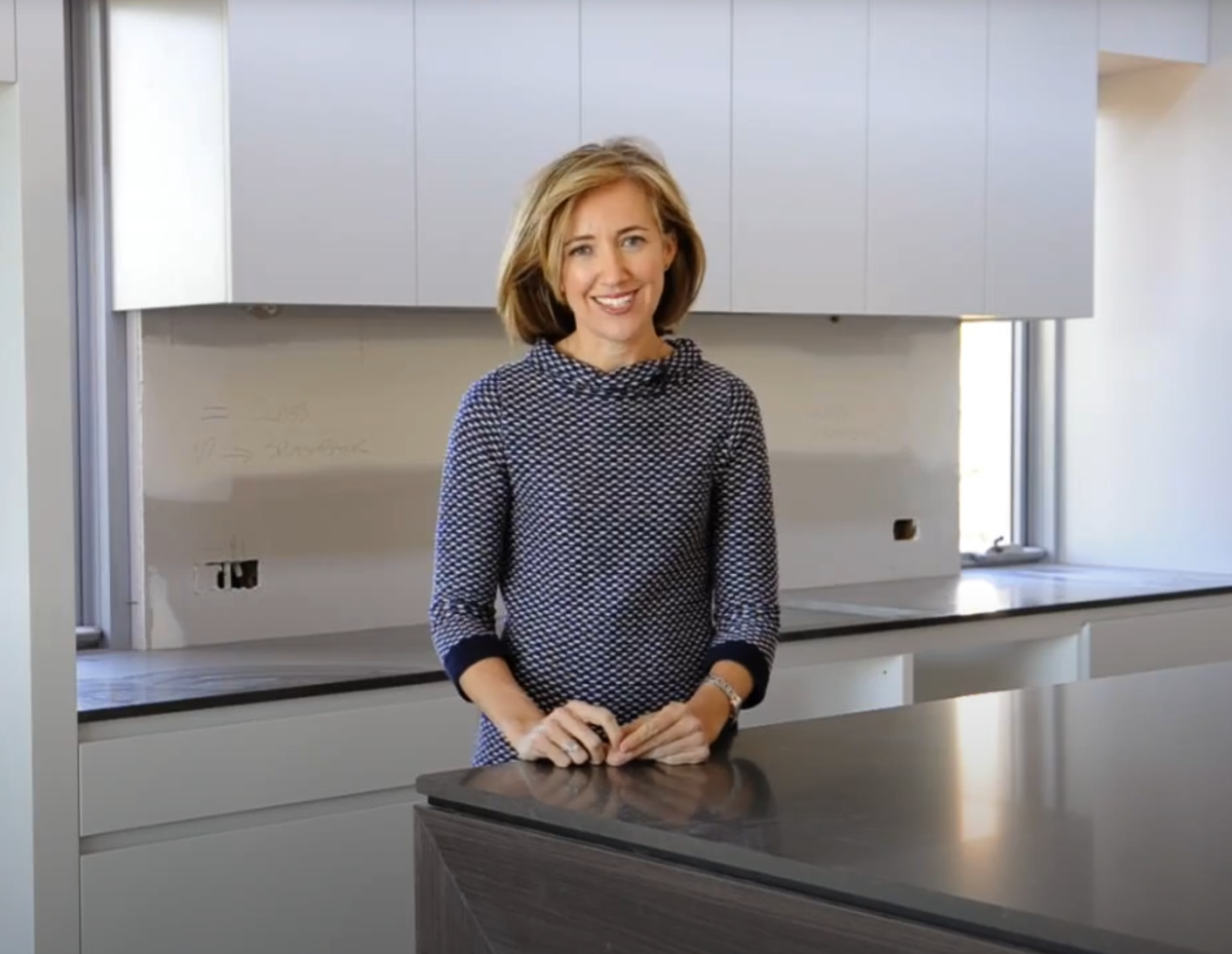 Well presented woman talking to the camera while standing in a kitchen