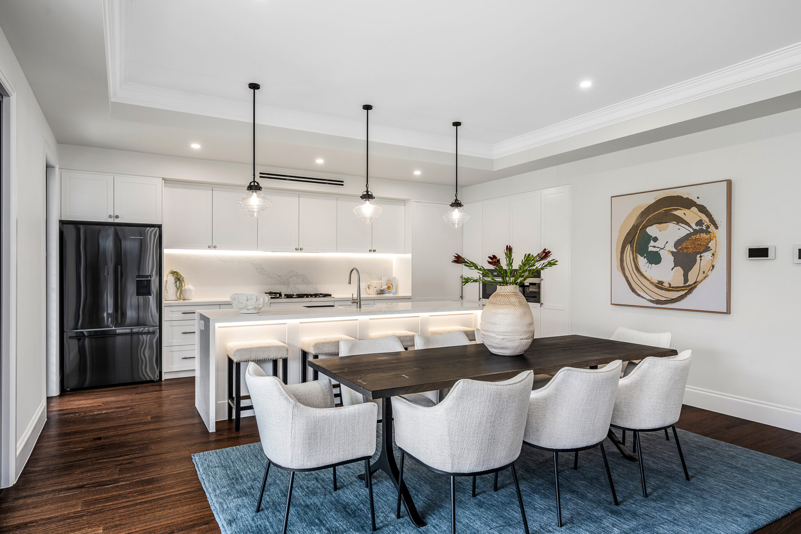 Classical Luxury with a kitchen and dining area with white cabinetry, stone island bench, pendant lighting and black-framed windows