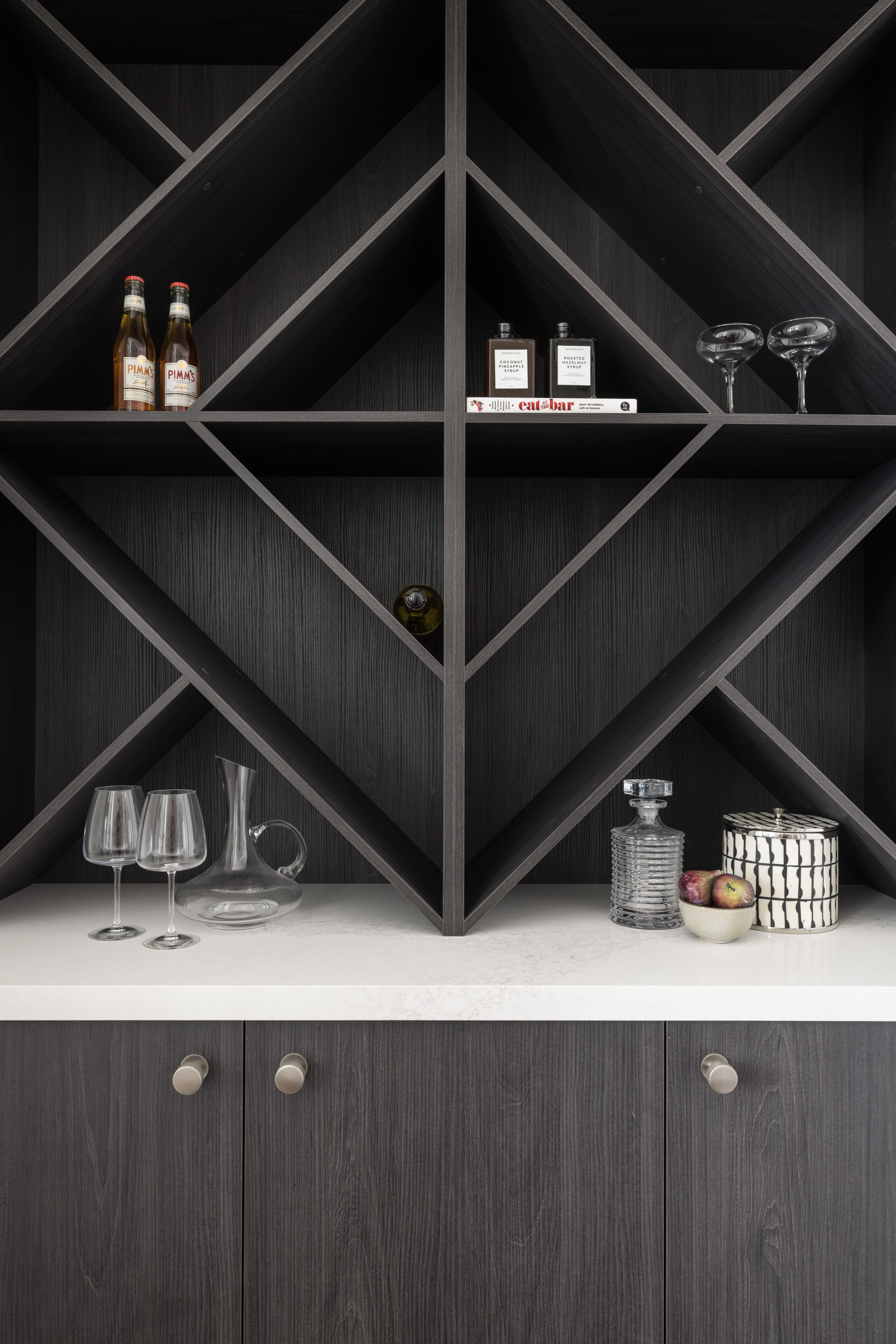 Custom dark timber wine storage with display shelving, glassware and decorative bar accessories