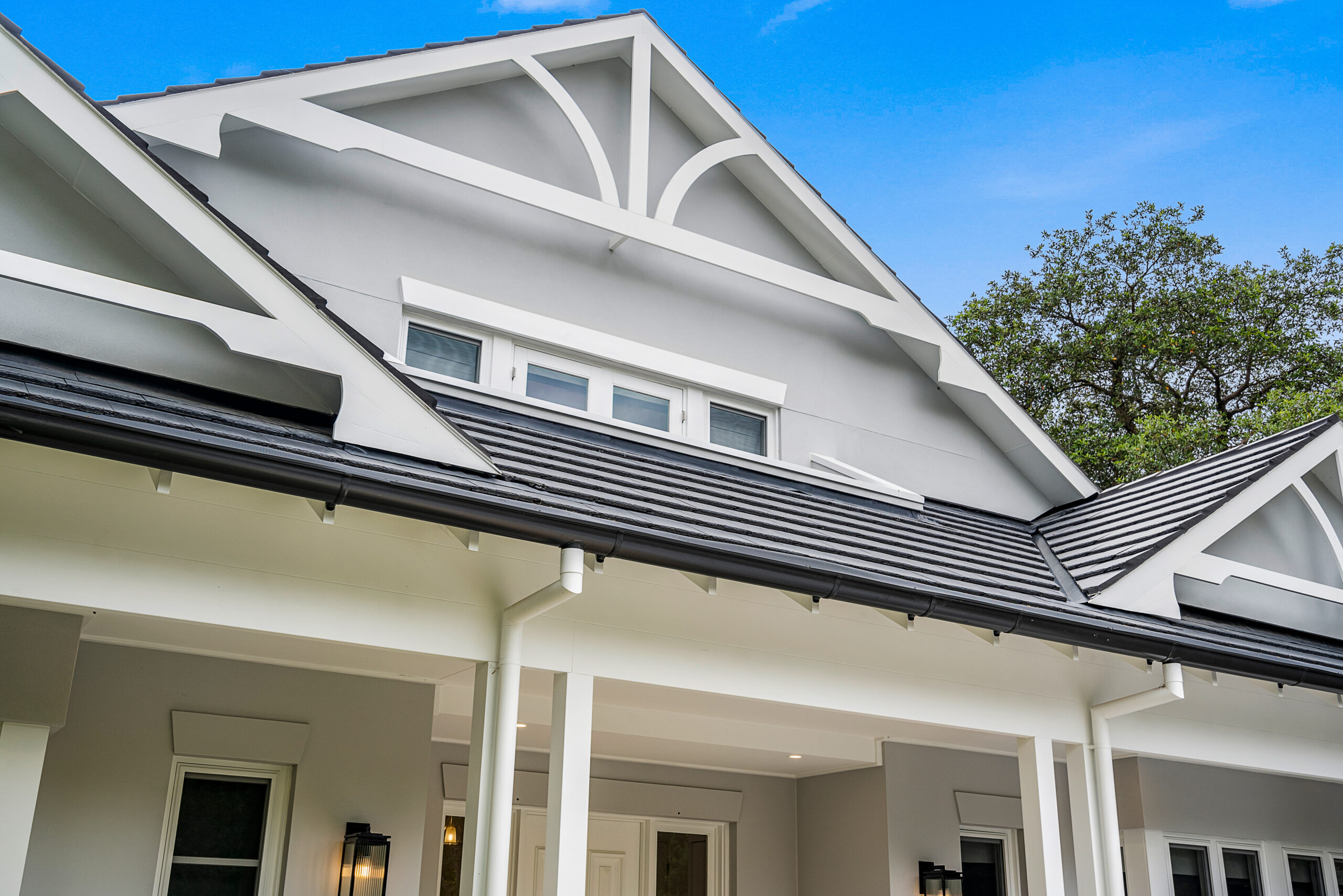 Contemporary Hamptons roofline with decorative gable detailing and a covered entry.