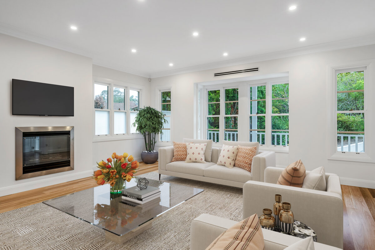 Light-filled formal living room with a fireplace, timber flooring and garden views.