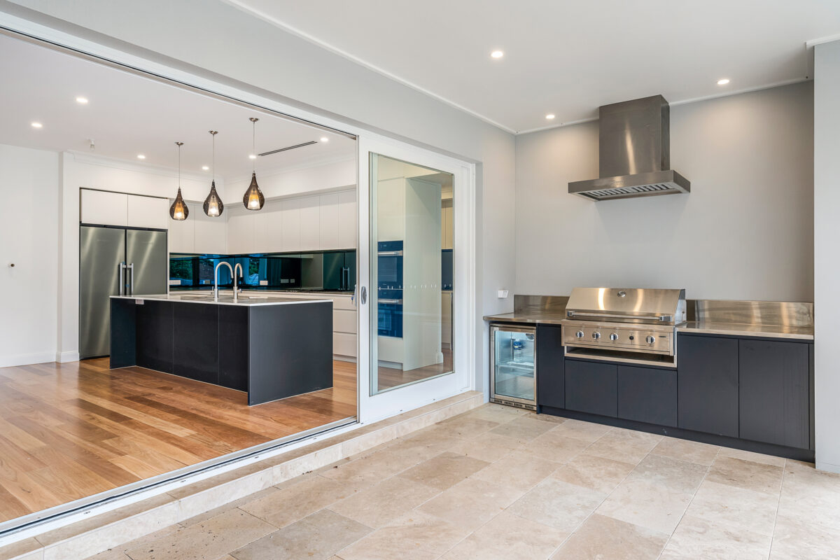 Serene bedroom with timber flooring, ensuite access and views of established greenery.